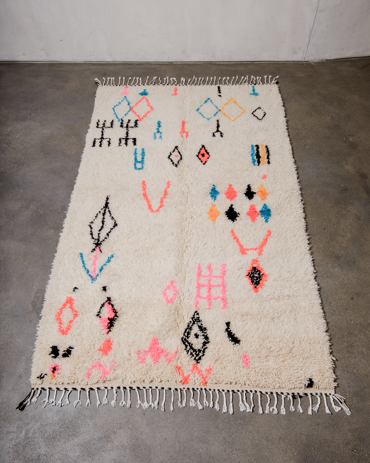 Berberlin Azilal rug made of fluffy wool and cotton, laying flat on a concrete floor.